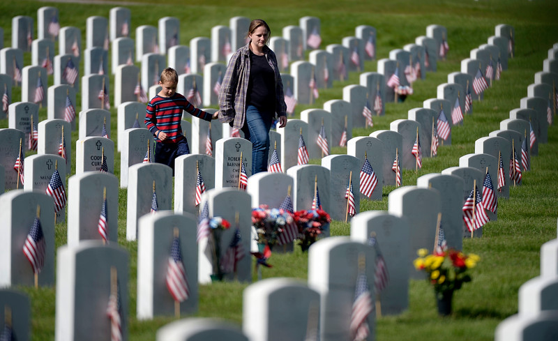 Bridgit Hangman and her son Logan Hangman holds hands as they walk the though the headstones at Ft. Logan Cemetery on Memorial Day. The 83rd Anniversary of Remembrance dedicated to America's Veterans of All Wars during a ceremony May 25, 2015 at Ft. Logan Cemetery in Denver. (Photo By John Leyba/The Denver Post)